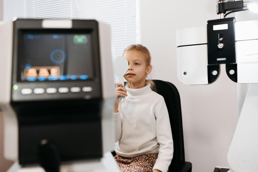 A Girl in White Top Covering Eye While Undergoing a Vision Test